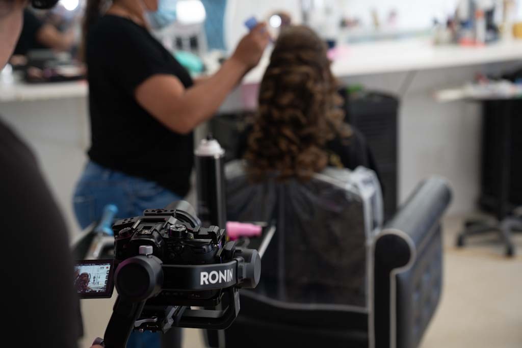 Camera on a Ronin gimbal filming a hairstyling session for social content.