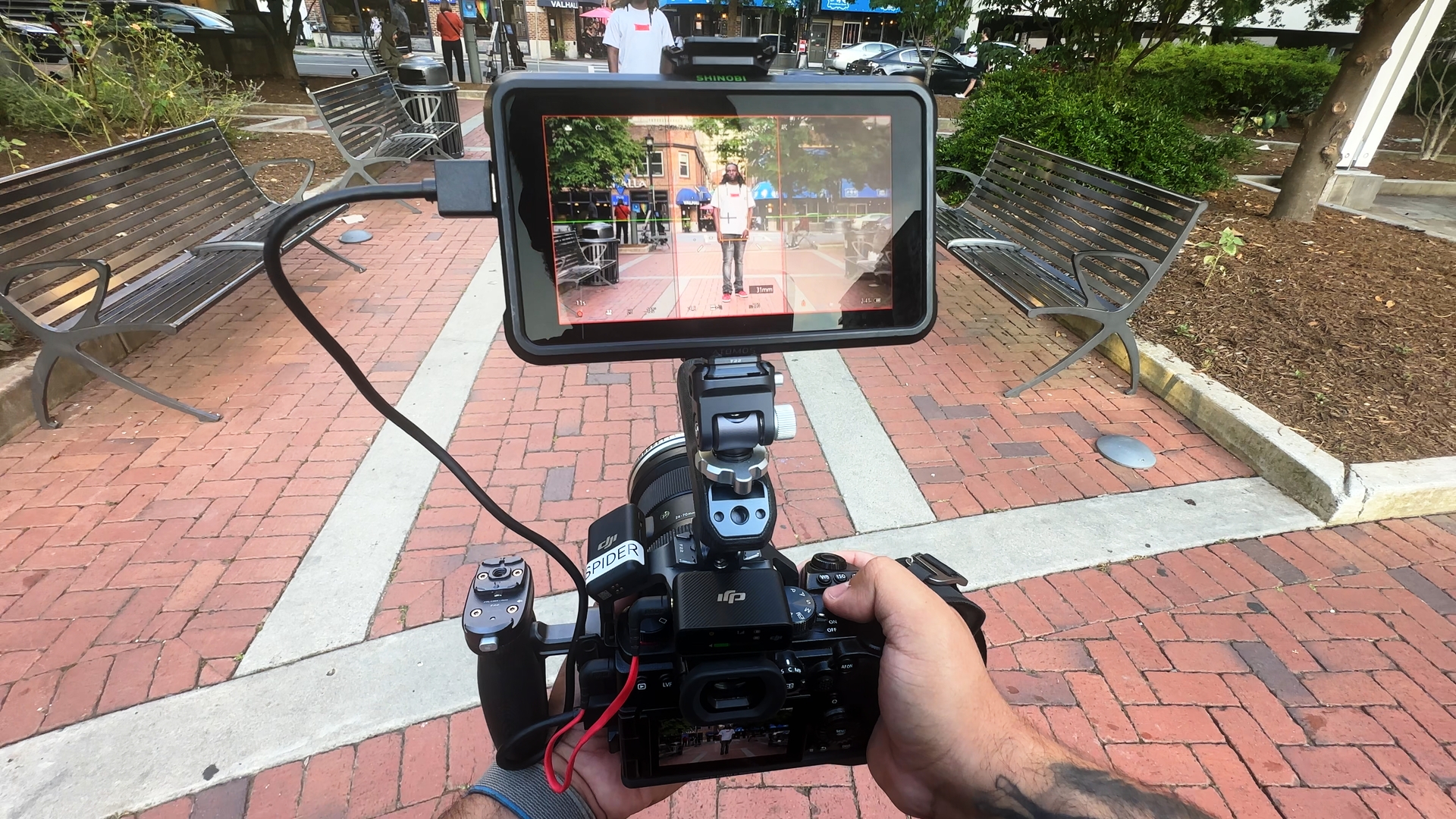 Handheld camera and monitor framing an on-location social media shoot.